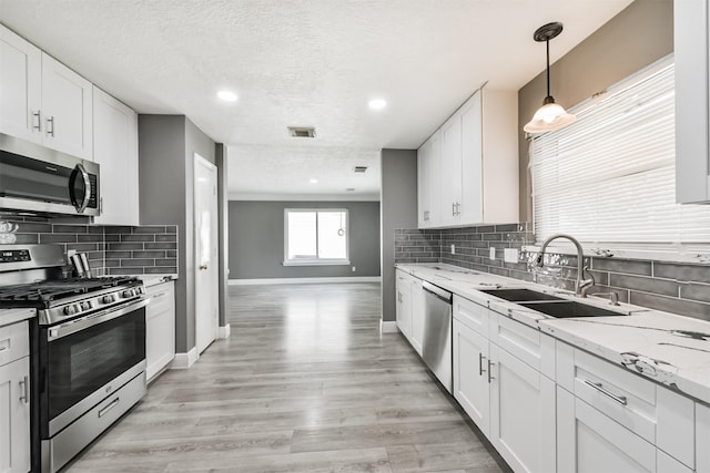 3626 Lake Breeze Ln, Crosby, TX 77532 - kitchen featuring a sink, visible vents, baseboards, backsplash, and appliances with stainless steel finishes