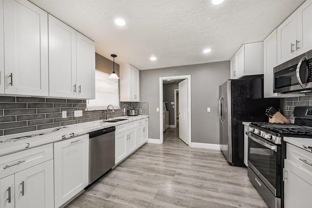 3626 Lake Breeze Ln, Crosby, TX 77532 - kitchen featuring white cabinets, stainless steel appliances, a sink, and backsplash