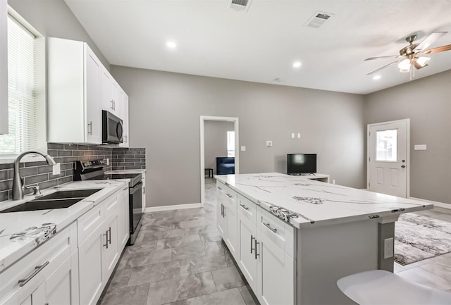 3626 Lake Breeze Ln, Crosby, TX 77532 - kitchen with a sink, visible vents, ceiling fan, a kitchen island, and appliances with stainless steel finishes