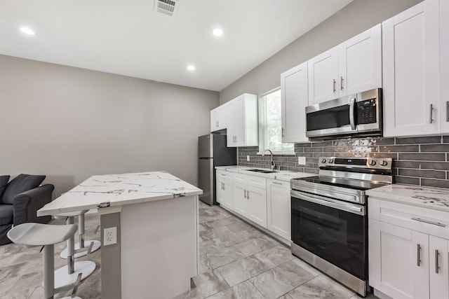 3626 Lake Breeze Ln, Crosby, TX 77532 - kitchen with a sink, decorative backsplash, marble finish floor, appliances with stainless steel finishes, and a kitchen island