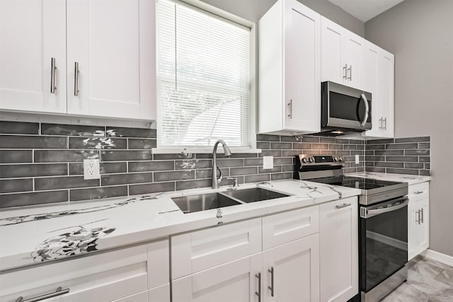 3626 Lake Breeze Ln, Crosby, TX 77532 - kitchen with marble finish floor, stainless steel appliances, a sink, tasteful backsplash, and white cabinetry