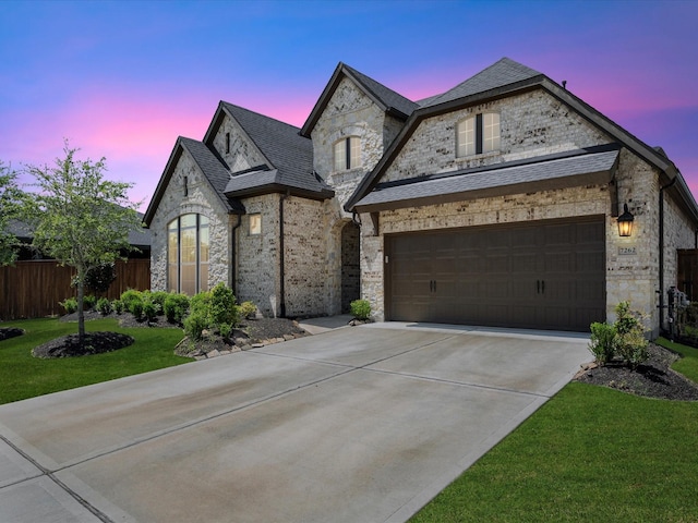 7262 Monarch Dr, Katy, TX 77493 - french provincial home featuring a garage, fence, driveway, stone siding, and a yard
