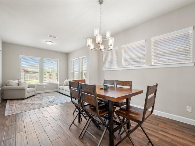 7262 Monarch Dr, Katy, TX 77493 - dining area featuring visible vents, baseboards, wood finished floors, and an inviting chandelier