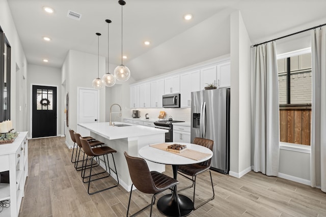 21131 Austin Chalk Dr, Cypress, TX 77433 - kitchen featuring a sink, appliances with stainless steel finishes, a center island with sink, white cabinetry, and visible vents