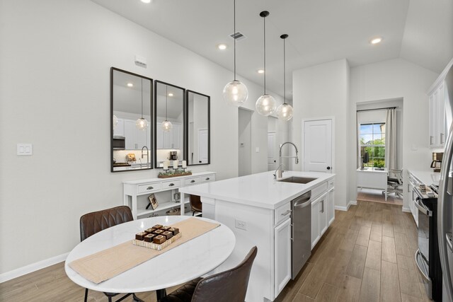 21131 Austin Chalk Dr, Cypress, TX 77433 - kitchen featuring stainless steel dishwasher, a sink, a center island with sink, baseboards, and white cabinetry