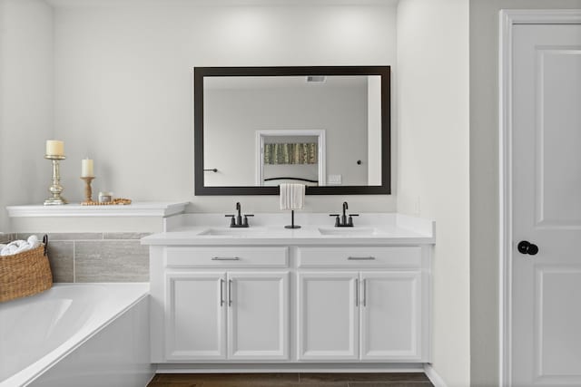 21131 Austin Chalk Dr, Cypress, TX 77433 - bathroom featuring a garden tub, a sink, and double vanity