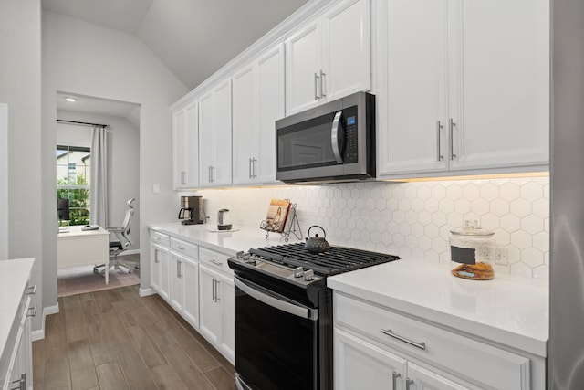 21131 Austin Chalk Dr, Cypress, TX 77433 - kitchen with backsplash, lofted ceiling, appliances with stainless steel finishes, and wood finished floors