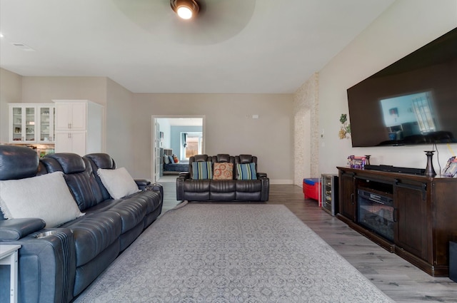 living room with light wood-style flooring, baseboards, and a ceiling fan