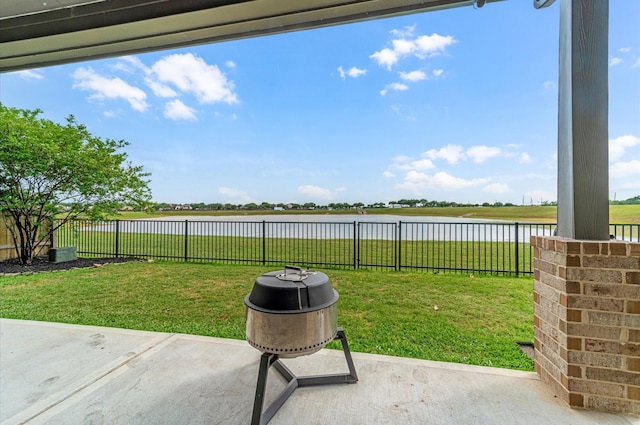 view of yard featuring a patio area, a fenced backyard, and a water view