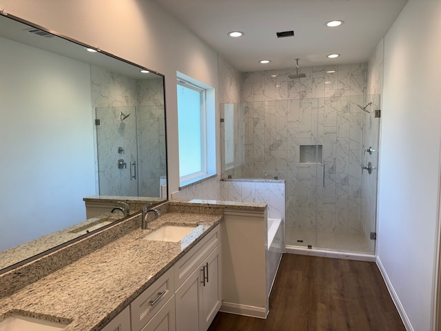 full bathroom with recessed lighting, wood finished floors, a sink, and a stall shower