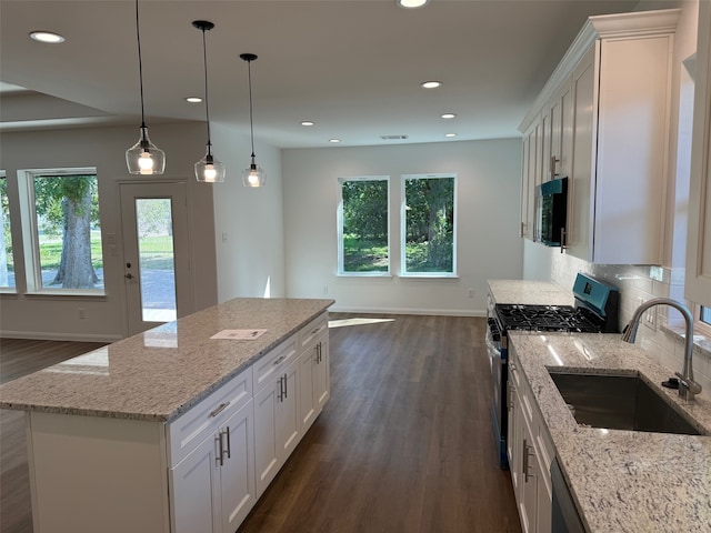 kitchen with baseboards, a sink, dark wood-type flooring, and stainless steel gas stove