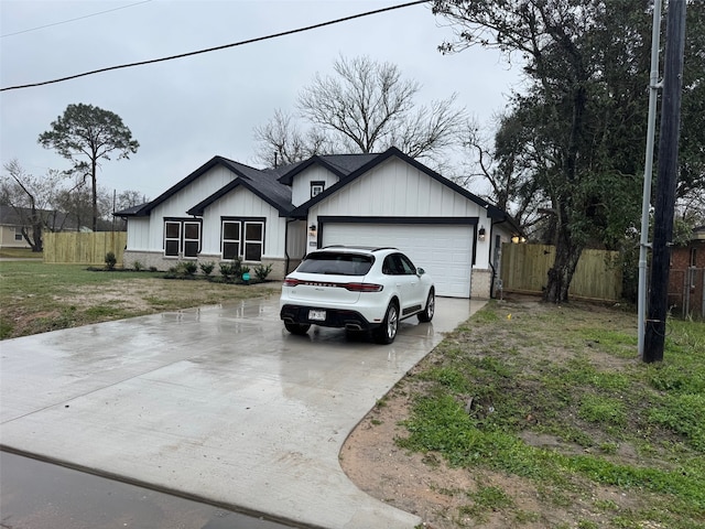 single story home featuring board and batten siding, an attached garage, fence, and concrete driveway