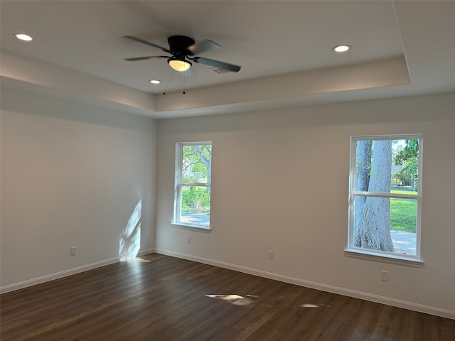 unfurnished room featuring ceiling fan, a raised ceiling, baseboards, dark wood-style floors, and recessed lighting