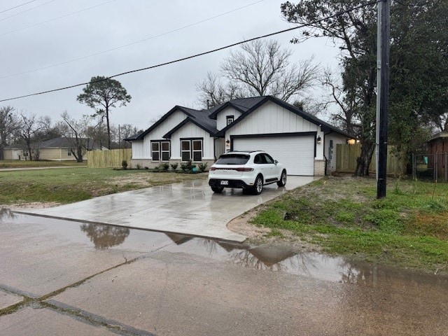 view of front of home with a front lawn, driveway, fence, and a garage