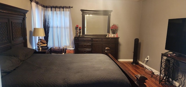 bedroom with dark wood finished floors and baseboards