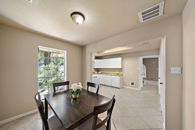 dining area with light tile patterned flooring, visible vents, and baseboards