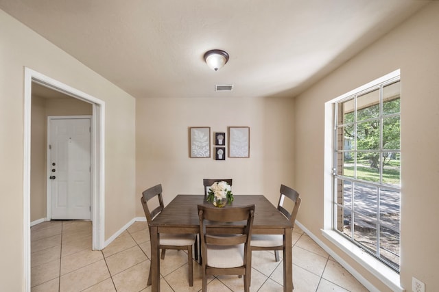 dining area with baseboards, visible vents, and light tile patterned floors