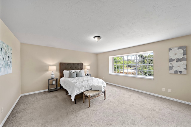 carpeted bedroom featuring baseboards and a textured ceiling