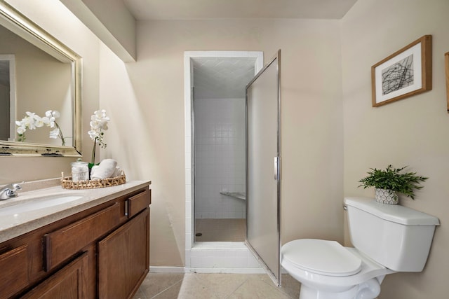 full bathroom featuring a tile shower, toilet, baseboards, tile patterned flooring, and vanity
