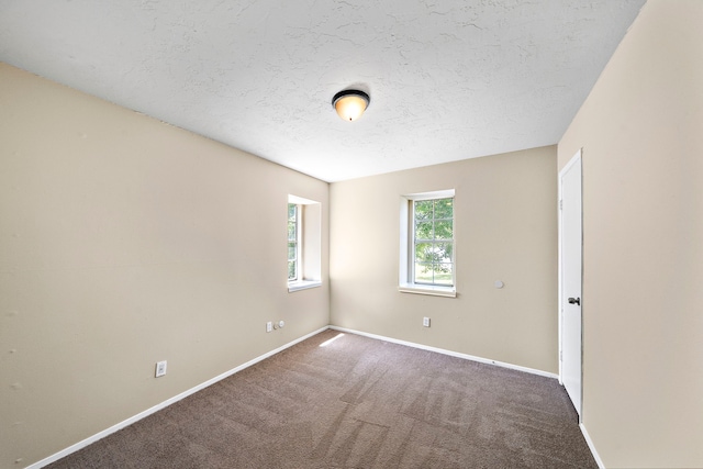 carpeted spare room with baseboards and a textured ceiling
