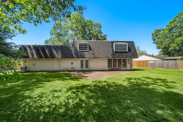 back of property featuring french doors, mansard roof, fence, a lawn, and a shingled roof
