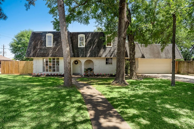 view of front of house with a front lawn, concrete driveway, fence, brick siding, and a shingled roof