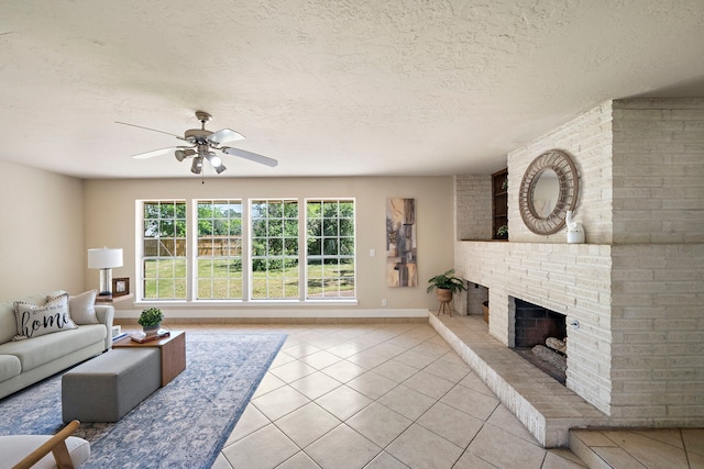 living area featuring a textured ceiling, light tile patterned flooring, baseboards, ceiling fan, and a fireplace