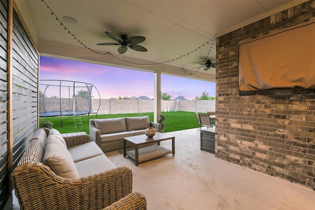 19219 Filly Park Cir, Tomball, TX 77377 - patio terrace at dusk featuring a trampoline, ceiling fan, and outdoor lounge area