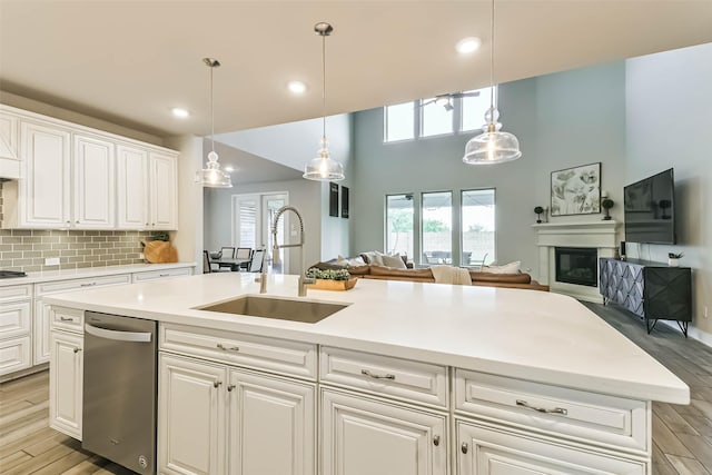 19219 Filly Park Cir, Tomball, TX 77377 - kitchen with a sink, dishwasher, open floor plan, light wood-type flooring, and light countertops
