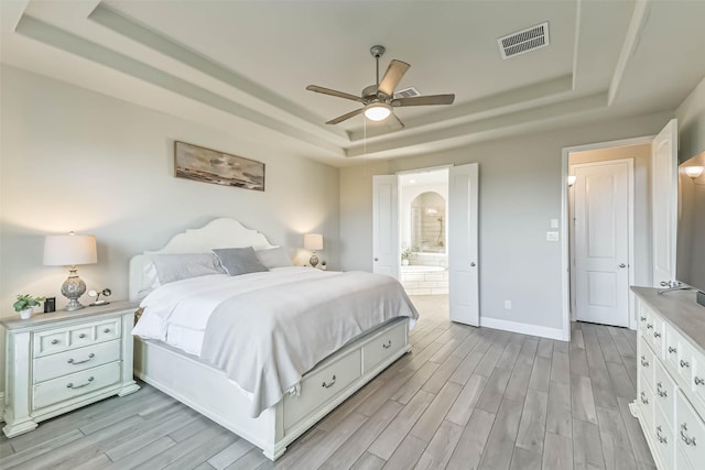 19219 Filly Park Cir, Tomball, TX 77377 - bedroom with a raised ceiling, light wood-style flooring, baseboards, ensuite bath, and ceiling fan