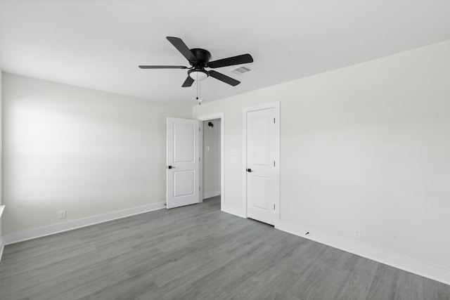 spare room featuring visible vents, baseboards, a ceiling fan, and wood finished floors