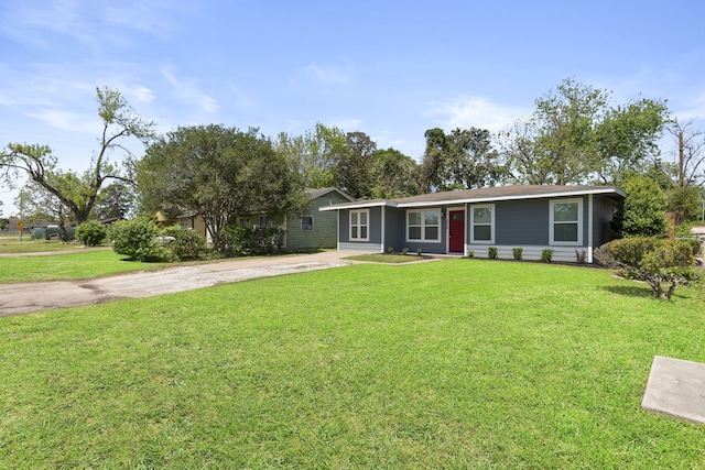 ranch-style home featuring concrete driveway and a front yard