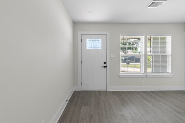 doorway featuring visible vents, baseboards, and wood finished floors