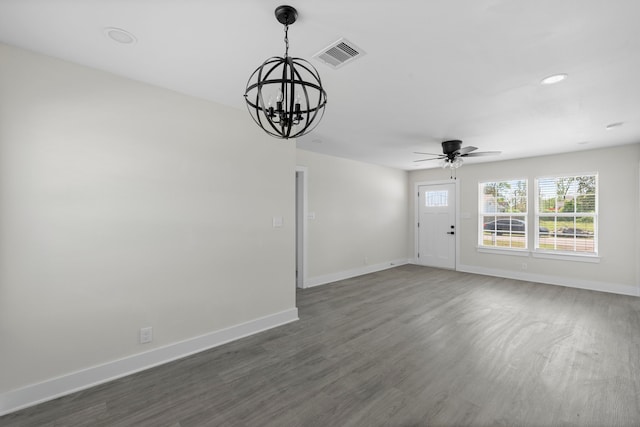 interior space featuring ceiling fan with notable chandelier, baseboards, visible vents, and dark wood finished floors