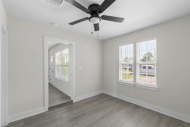 unfurnished room featuring visible vents, baseboards, a ceiling fan, and wood finished floors