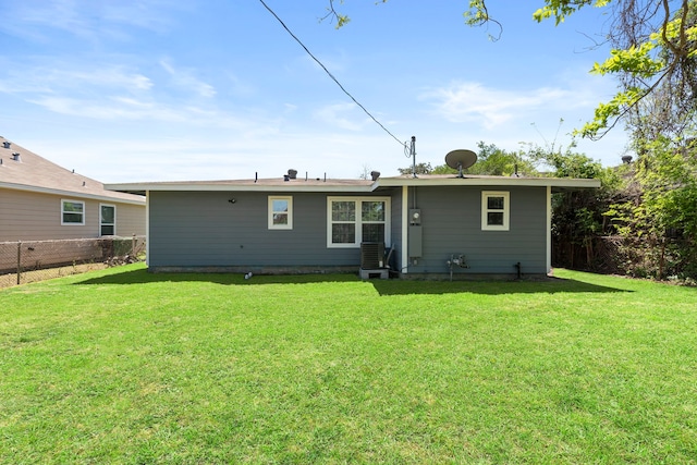 rear view of property with a yard and fence