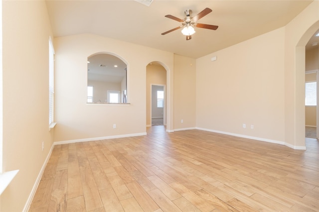 21527 Cotton Valley Ln, Porter, TX 77365 - unfurnished room with arched walkways, light wood finished floors, baseboards, and ceiling fan