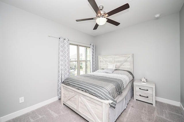bedroom with light carpet, a ceiling fan, and baseboards