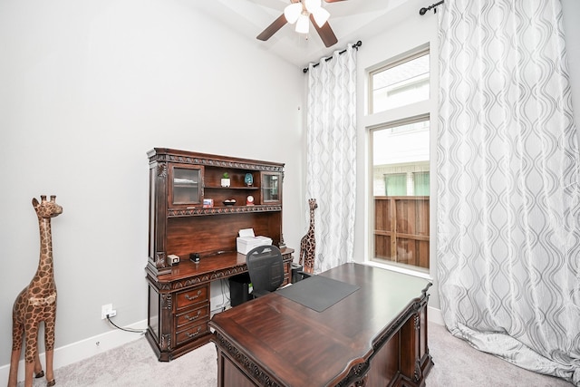 office space featuring light colored carpet, baseboards, and a ceiling fan