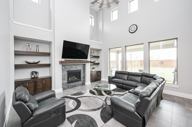 living area with a wealth of natural light, built in features, baseboards, and a high ceiling