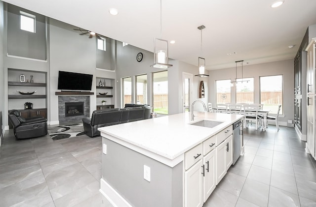 kitchen featuring light countertops, a sink, built in shelves, and ceiling fan