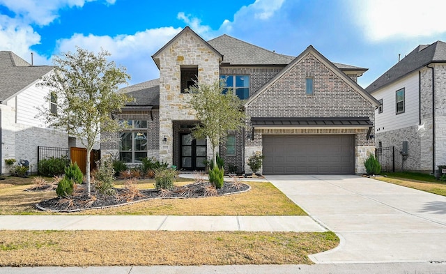 view of front of house with stone siding, concrete driveway, fence, a garage, and brick siding