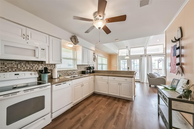 kitchen featuring decorative backsplash, white appliances, a peninsula, dark wood-type flooring, and visible vents