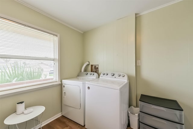laundry area featuring baseboards, separate washer and dryer, wood finished floors, laundry area, and ornamental molding
