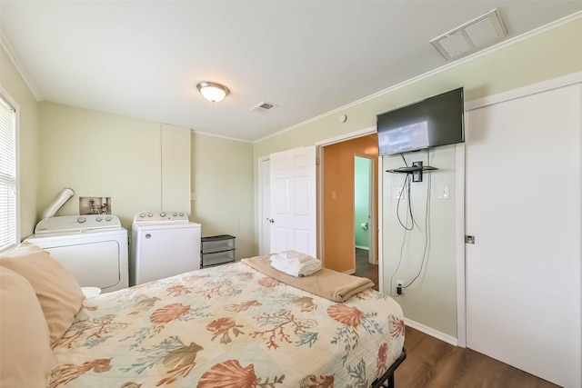 bedroom with washing machine and dryer, visible vents, crown molding, and dark wood finished floors