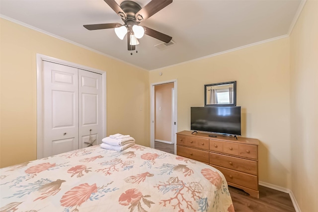 bedroom with a closet, visible vents, crown molding, and baseboards