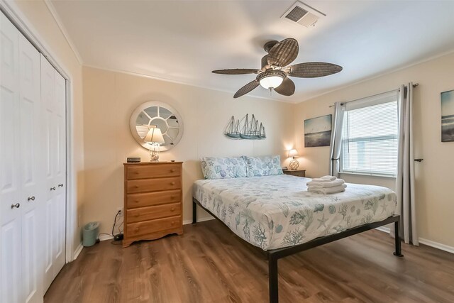bedroom featuring wood finished floors, visible vents, a closet, baseboards, and ceiling fan