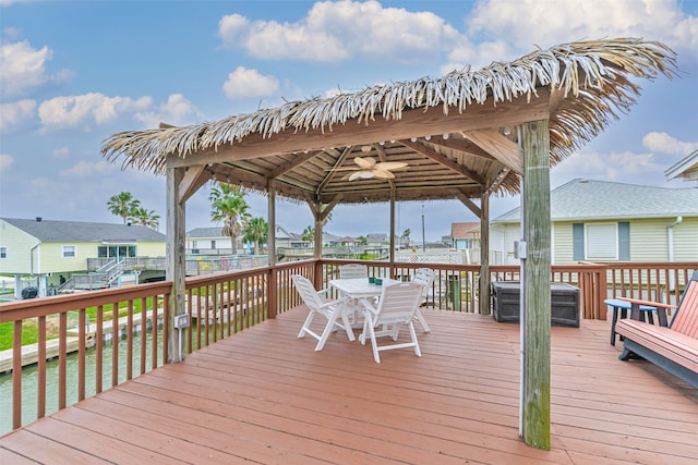 wooden terrace with a gazebo, a residential view, and outdoor dining space