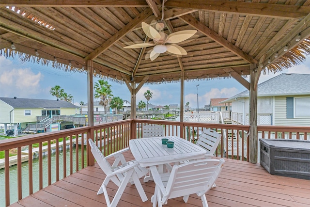 deck with outdoor dining area, a ceiling fan, a gazebo, and a residential view