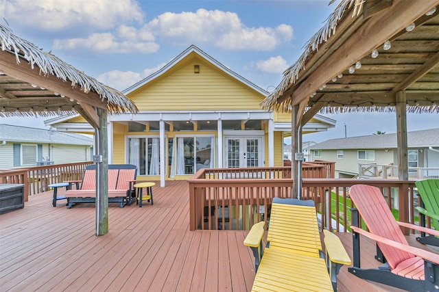 wooden deck with a sunroom and french doors